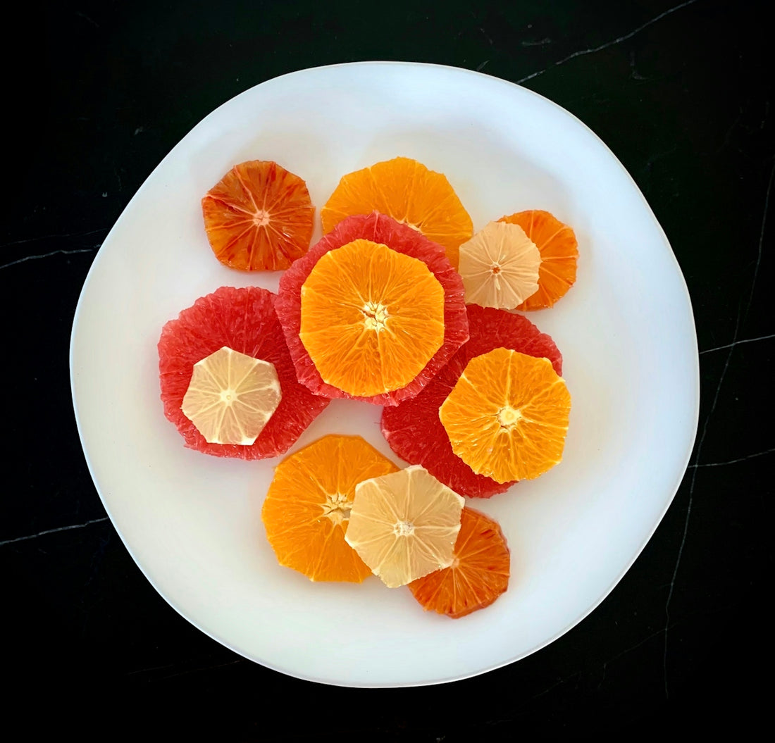 a white plate topped with sliced oranges on top of a table