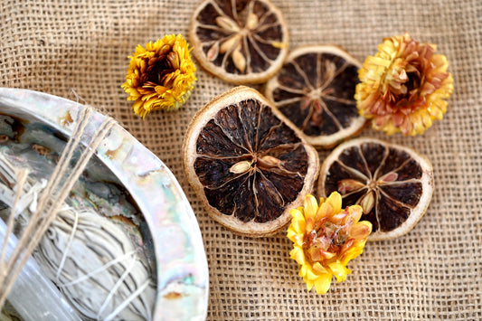 dried oranges on a table with a plate and flowers