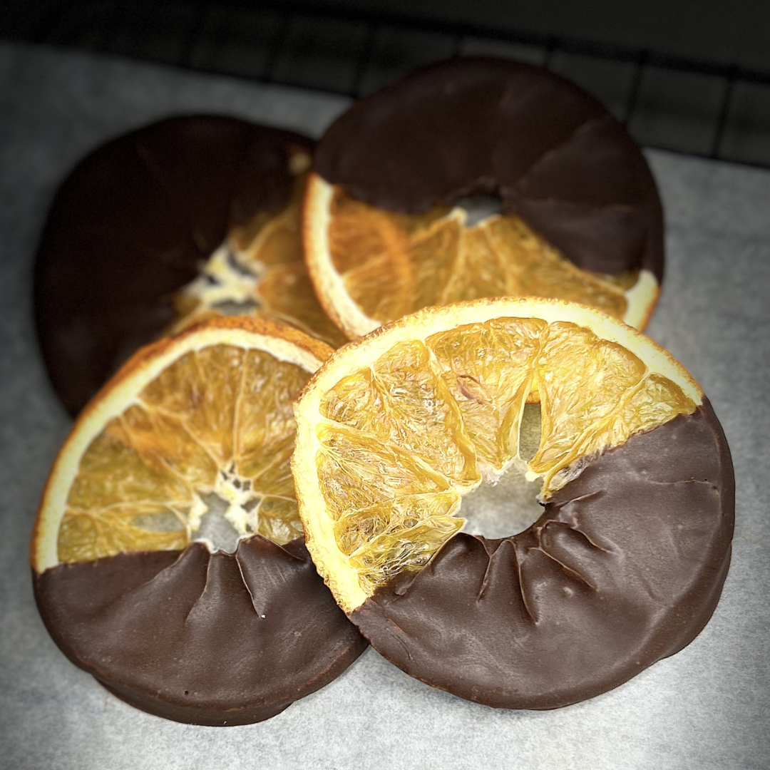 Dried orange wheel half-dipped in dark chocolate